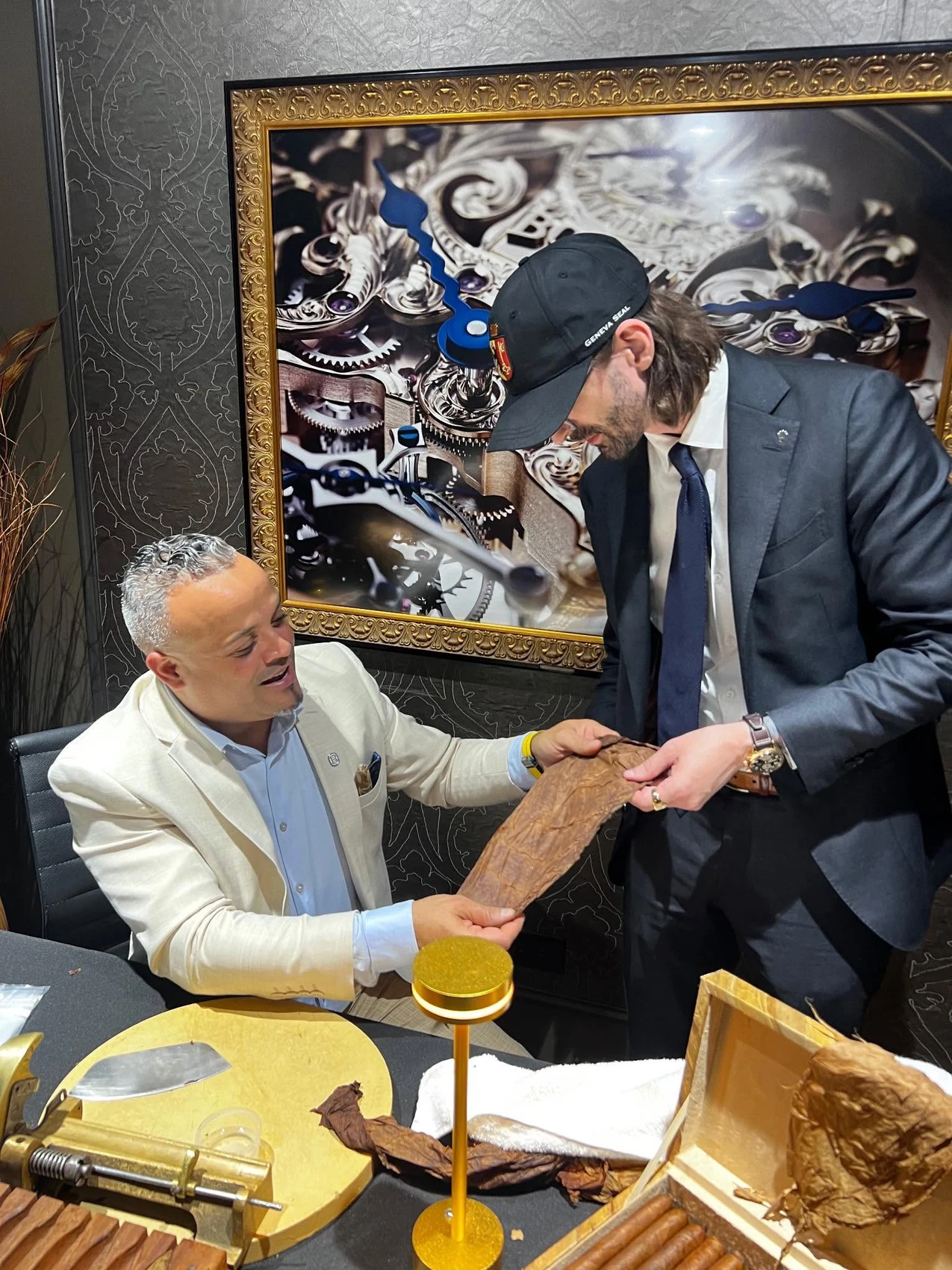 Franklin Pichardo handing a rolled cigar to a guest at an event