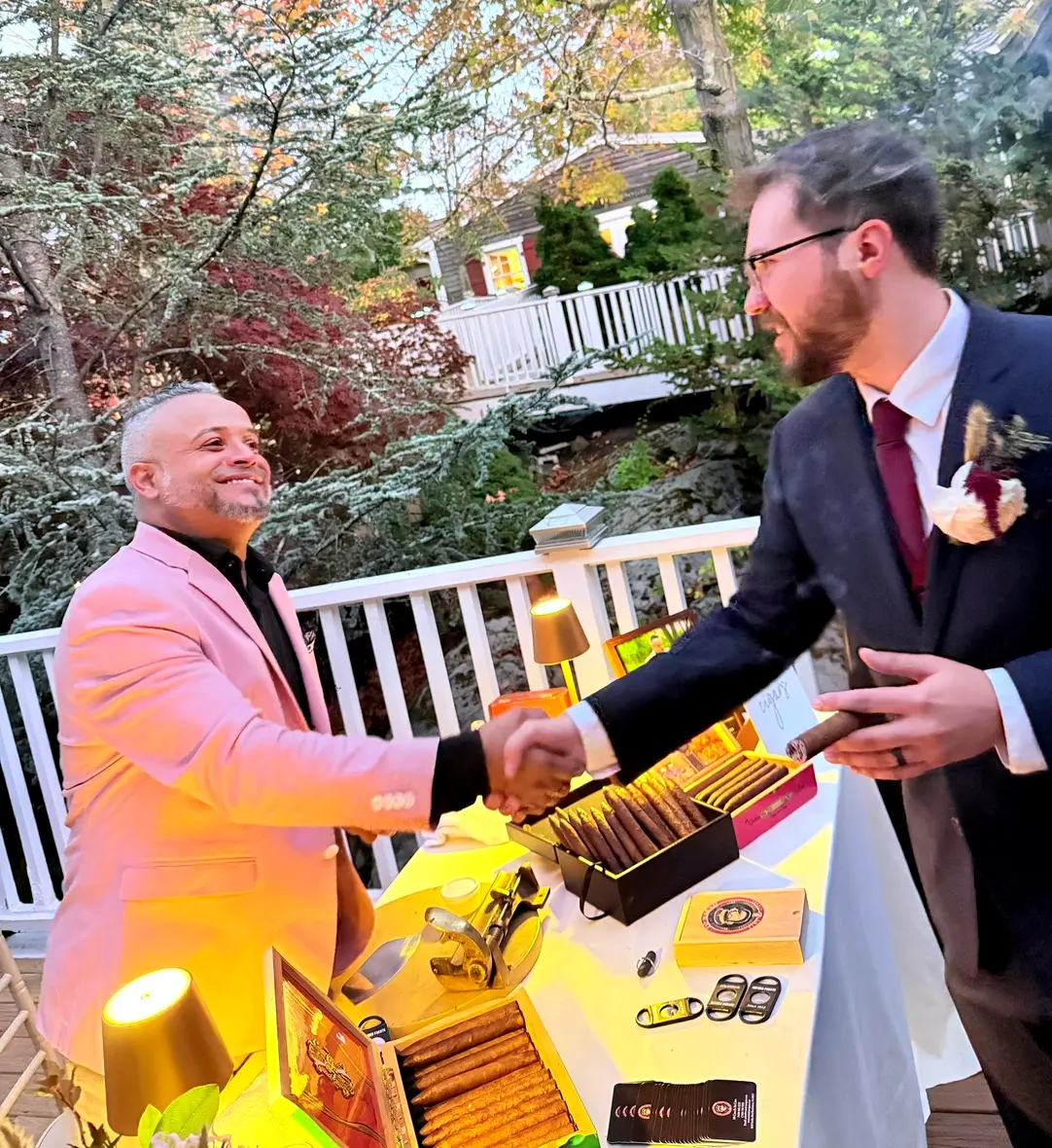Franklin shaking hands with a guest across his table on the deck