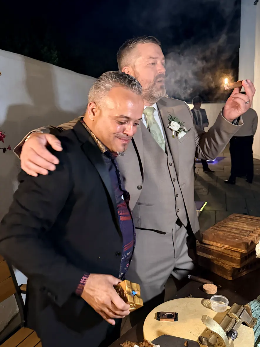 Franklin with his arm around the groom, both of them smoking