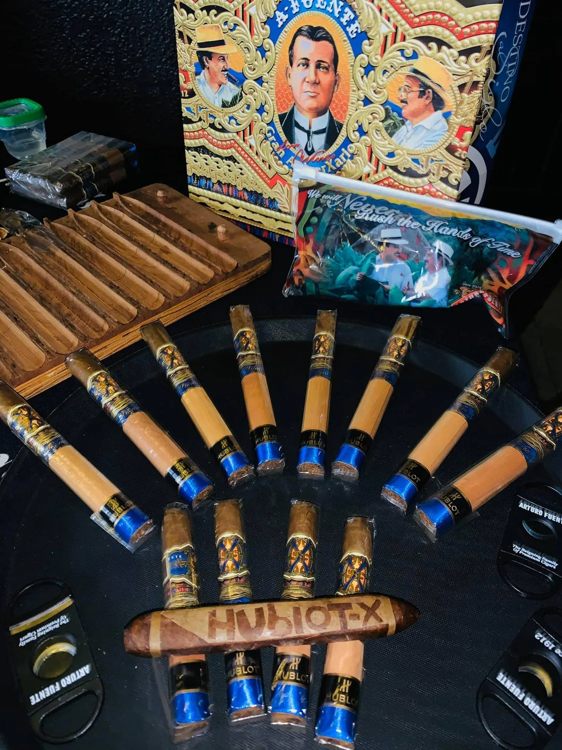 A fan of cigars laid out on his table, every one of them wearing a printed blue band