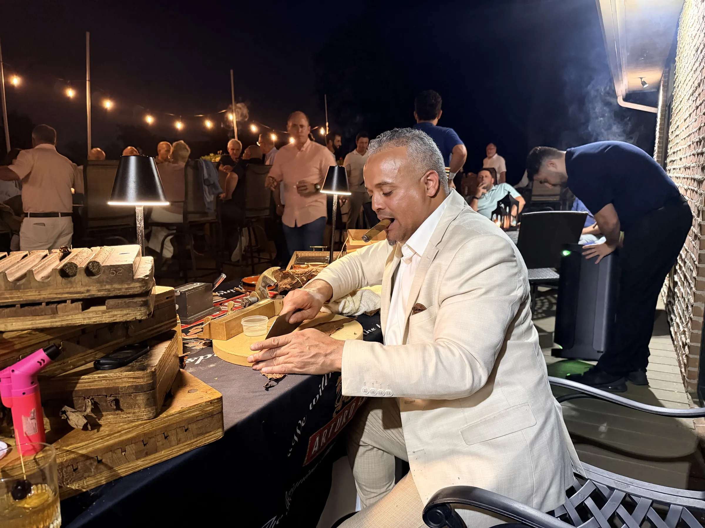 Franklin rolling at his table on a New Jersey country club terrace at night, members gathered under the string lights behind him