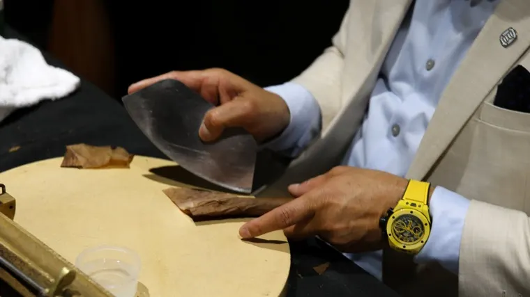 His hands working a wrapper leaf with the chaveta