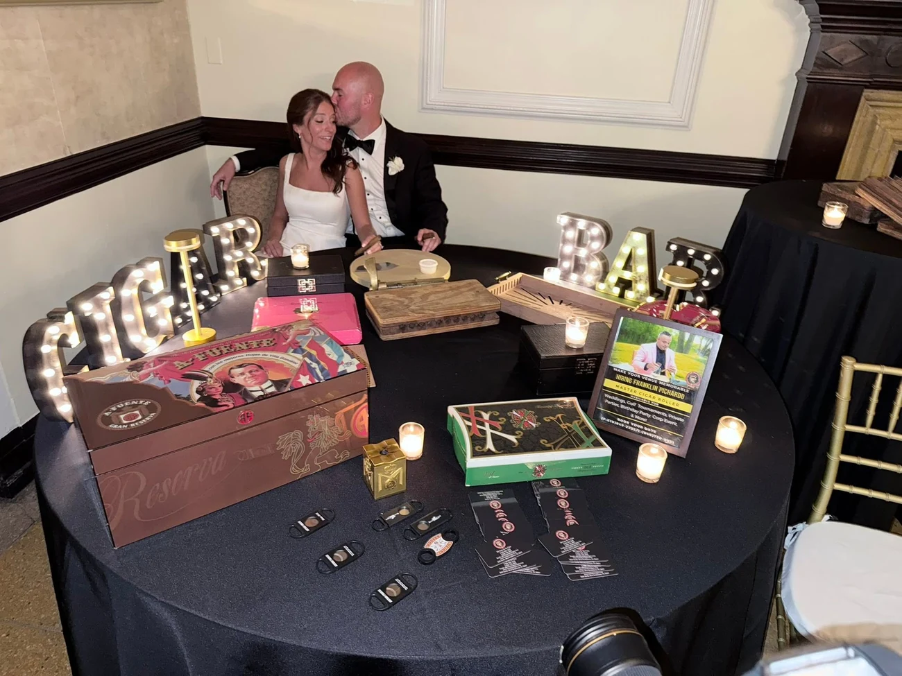 The round table draped in black to the floor, with the letters, the boxes and the candles